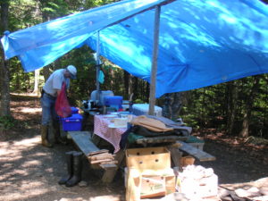 Blue tarp set up over picnic table to keep us dry